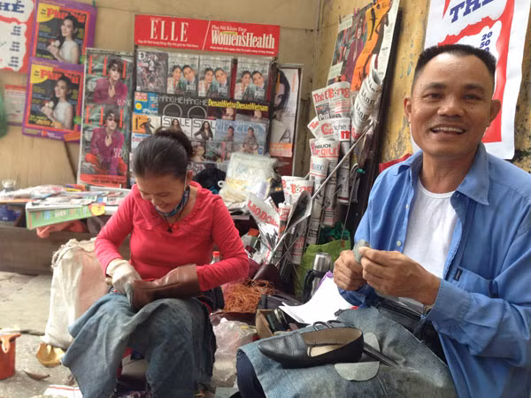 Vợ chồng anh Thân giờ hạnh phúc với công việc bán báo, đánh giày.