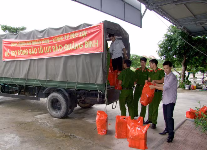 Đoàn công tác xã hội từ thiện của Báo CAND và Công ty Duy Lợi sắp xếp hàng cứu trợ lên xe để đưa về vùng lũ Quảng Bình.