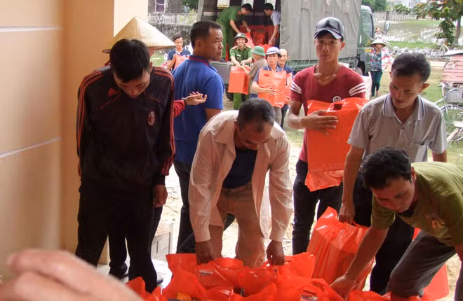 Đoàn công tác của Báo CAND và Công ty Duy lợi cùng Công an thị xã Ba Đồn và người dân vận chuyển hàng cứu trợ để giúp đỡ bà con.