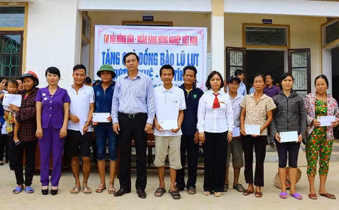Đại diện Agribank chi nhánh Hà Tĩnh tặng quà bà con vùng lũ xã Hà Linh, huyện Hương Khê.