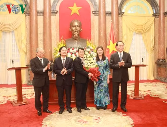 Chủ tịch nước Trần Đại Quang tặng hoa cho các tân Giáo sư, Phó Giáo sư năm 2016.