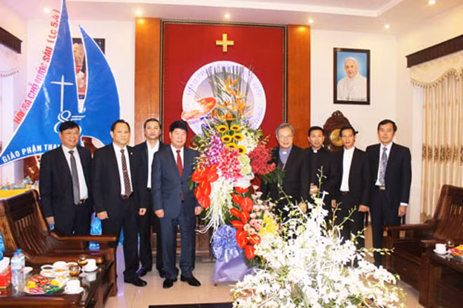 Thứ trưởng Bùi Văn Nam tặng hoa chúc mừng lễ Giáng sinh Đức Giám mục Nguyễn Chí Linh.