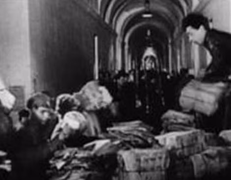 Chủ tịch Ủy ban Quân sự Cách mạng Vladimir Antonov-Ovseyenko (người ngồi bên trái), tiến hành kiểm kê đóng gói bảo quản các hiện vật văn hóa trong Cung điện Mùa đông.