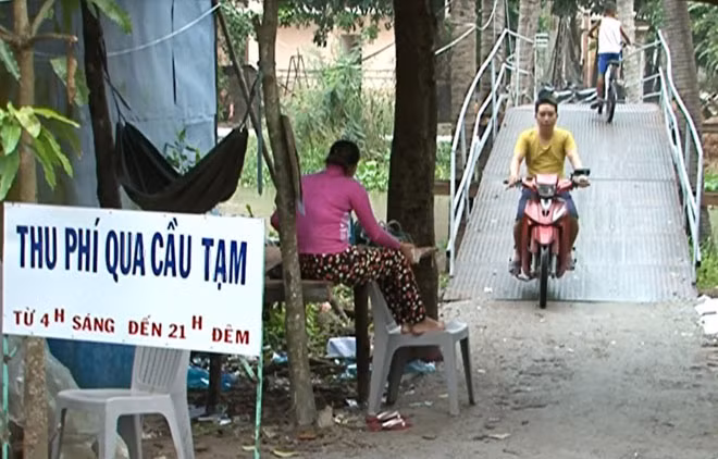 Qua cầu tạm là phải nộp phí, đang gây bức xúc với người dân nơi đây.