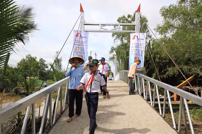 Người dân, em học sinh vui mừng đi trên cây cầu thép dây văng vừa khánh thành.