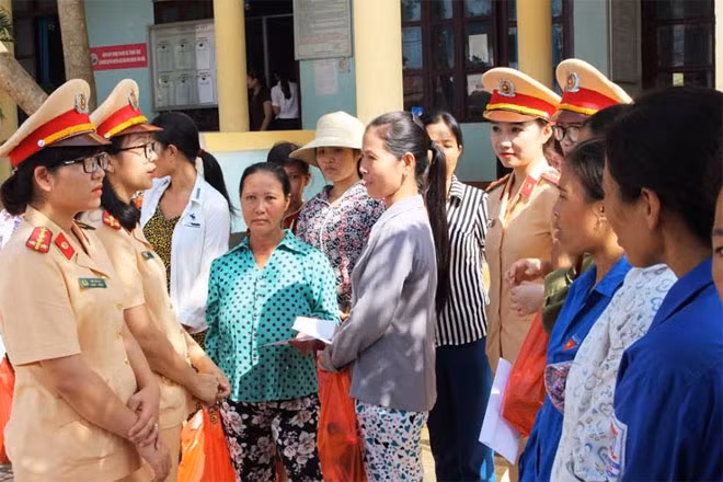Các nữ CSGT hỏi thăm, nói chuyện thân mật, động viên với chị em vùng lũ có hoàn cảnh khó khăn.