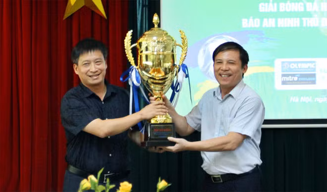 Ông Nguyễn Thanh Bình - Tổng biên tập Báo ANTĐ, Trưởng BTC giải (bên trái), nhận cúp vô địch giải từ ông Phạm Ngọc Tuấn - Trưởng phòng Công tác HSSV Sở GD-ĐT Hà Nội.