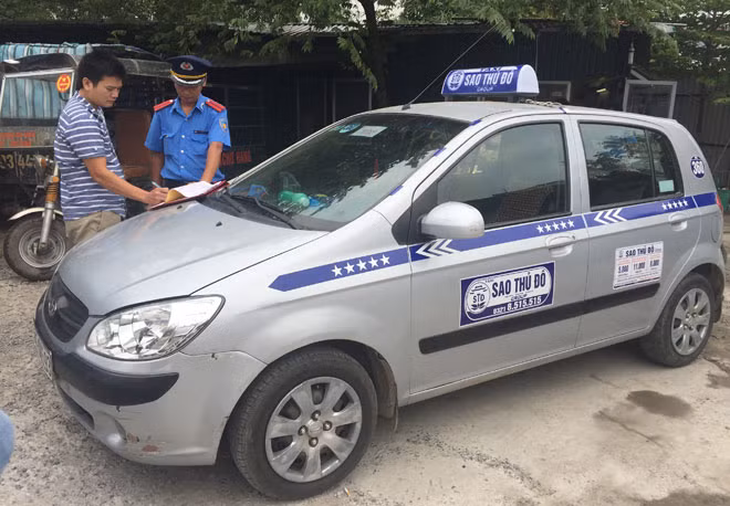 Thanh tra giao thông lập biên bản xử phạt taxi mang phù hiệu do tỉnh Hưng Yên cấp, vi phạm giao thông trên địa bàn Hà Nội.
