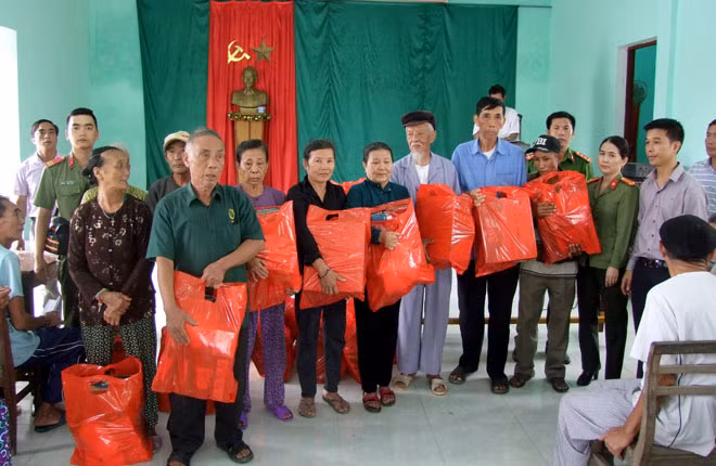 Đoàn công tác xã hội từ thiện của Báo CAND và Công ty Duy Lợi sắp xếp hàng cứu trợ lên xe để đưa về vùng lũ Quảng Bình.