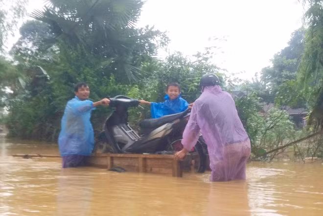 Các em nhỏ được bố mẹ đưa đi chạy lũ. Toàn huyện Hương Khê có 3 trường học bị ngập, hơn 4.600 học sinh 3 cấp phải nghỉ học.