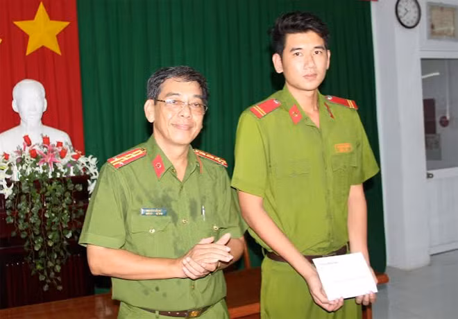 Đại tá Nguyễn Tấn Mỹ, Trưởng phòng Cảnh sát cơ động Công an tỉnh trao thưởng cho Trung sĩ Nguyễn Thái Ngạn.