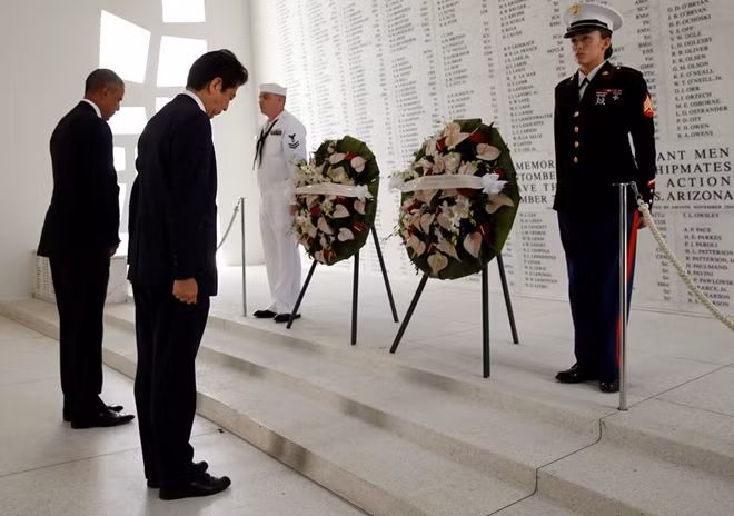 Hai nhà lãnh đạo cúi đầu mặc niệm, đặt vòng hoa tưởng niệm. Ảnh: Reuters