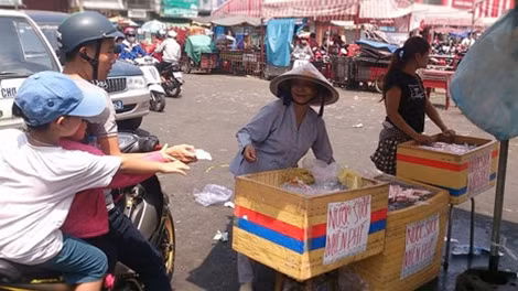 Bà Mười phát nước suối trước chợ Thủ Dầu Một cho biết, nước suối và bánh mì của cô là do tiểu thương của chợ "hùn" lại. Sáng nay đã phát được 4000 ổ bánh mì chay và gần 10000 chai nước suối.