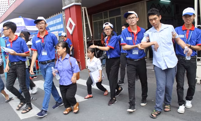 Các thí sinh khuyết tật được các tình nguyện viên nhiệt tình hỗ trợ tại điểm thi