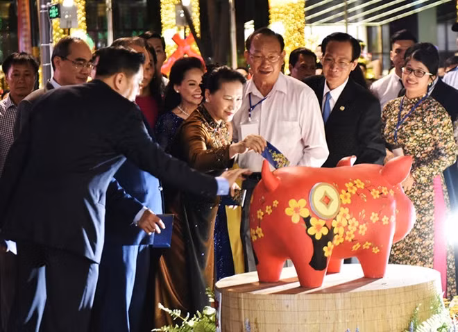 Chủ tịch Quốc hội cùng các đại biểu tham quan đường hoa và bỏ lì xì vào heo đất với tên gọi thân thương - Nuôi heo đất “Tết làm điều hay, chung tay đóng góp cho học sinh nghèo TP Hồ Chí M”.
