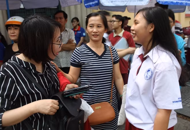 Cô giáo đợi học trò ở cổng trường điểm thi để chia vui.