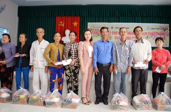 Đại diện Công ty TNHH Giấy Lee&Man cùng đại diện thị trấn Mái Dầm trao quà cho người dân.