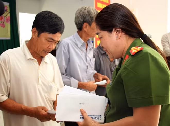 Trung tá Nguyễn Thị Phượng - Phó trưởng Công an huyện Châu Thành trao quà Tết và tuyên truyền, nhắc nhở bà con vui Xuân đón Tết an toàn, lành mạnh, không tham gia các tệ nạn xã hội.