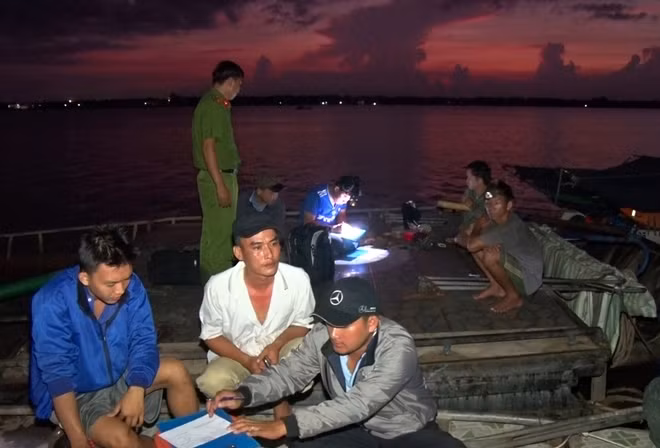 Tổ công tác Phòng Cảnh sát môi trường Công an tỉnh Bến Tre làm việc với các đối tượng khai thác cát trái phép trên sông Hàm Luông.