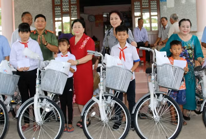 Đại diện Báo CAND, gia đình ông Nguyễn Văn Khuynh, Công ty CP môi trường Tân Thiên Nhiên trao tặng xe đạp cho các em học sinh.