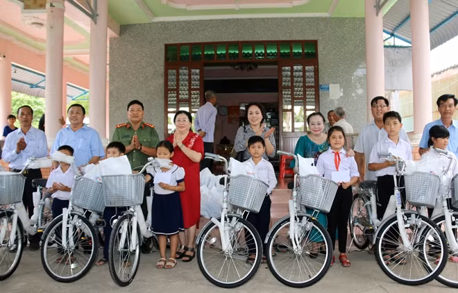 Đại diện Báo CAND, Mạnh thường quân, Huyện ủy, UBND huyện Long Phú và chính quyền địa phương trao tặng xe đạp và học bổng cho các em học sinh.
