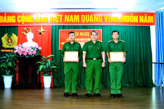 Đại tá Nguyễn Tấn Phước, Phó Giám đốc Công an tỉnh An Giang trao tặng giấy khen của Giám đốc Công an tỉnh cho Thiếu tá Đoàn Quốc Tuấn và Thiếu tá Lê Minh Chiến.