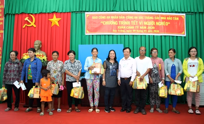 Chị Lê Thị Lệ Thủy cùng đại diện chính quyền địa phương trao quà cho bà con khó khăn.
