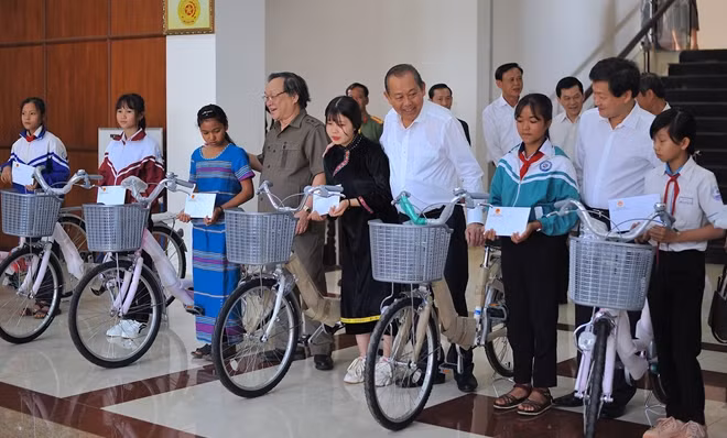 Phó Thủ tướng Thường trực Trương Hoà Bình cùng các nhà hảo tâm trao tặng xe đạp cho các em học sinh.