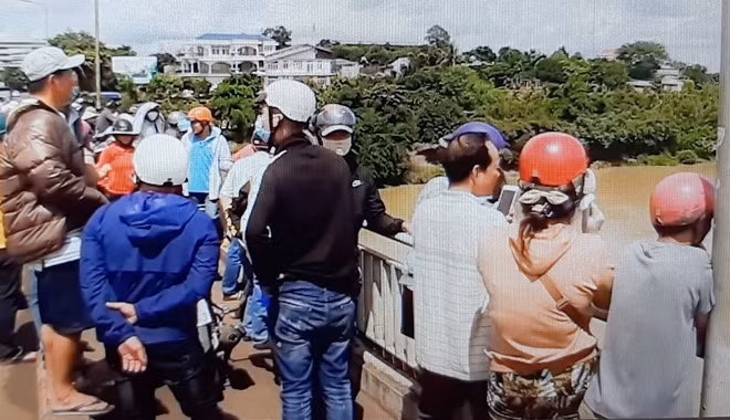 Người dân hiếu kỳ đứng trên cầu xem lực lượng chức năng tìm kiếm người mất tích