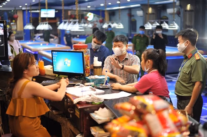 Ông Đoàn Ngọc Thượng (áo sọc), Trưởng đoàn liên ngành TP nhắc nhở một chủ kinh doanh thực hiện nghiêm chỉ đạo của Thủ tướng