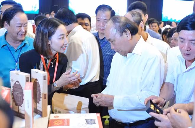 Thủ tướng Chính phủ Nguyễn Xuân Phúc cùng các đại biểu nghe doanh nghiệp giới thiệu về trái Mắc ca tại Hội nghị