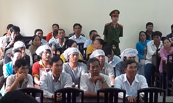 Các con của bà Liên đội khăn trắng trên đầu đến dự phiên tòa.