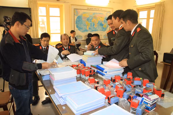 Cơ quan ANĐT Công an TP Hà Nội kiểm đếm số tang vật thu giữ trong vụ án mua bán hóa đơn GTGT.