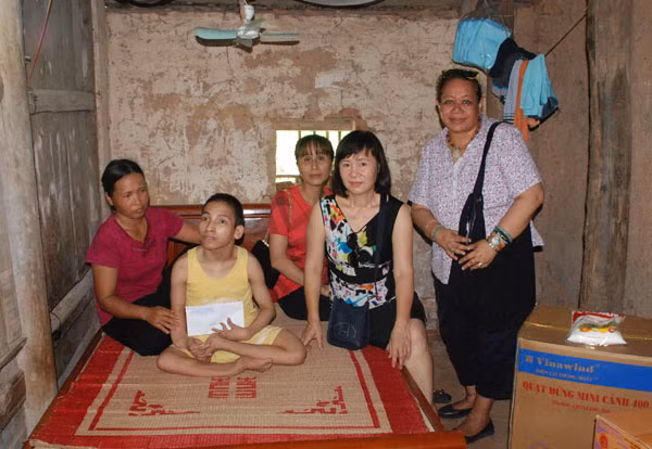 Bà Lương Thị Lợi (thứ hai từ phải qua) trao quà cho gia đình chị Nguyễn Thị Cam.