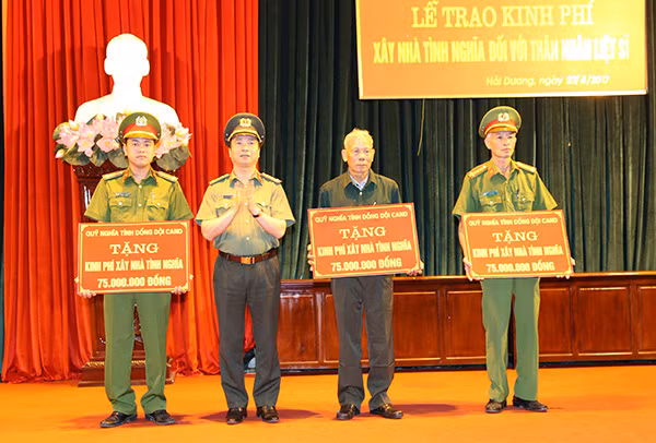 Đại tá Bùi Ngọc Phi, Giám đốc Công an tỉnh Hải Dương trao tiền xây nhà tình nghĩa cho 3 gia đình liệt sĩ.
