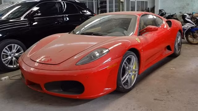 Ferrari F430 nằm tại 1 garage với ngoại thất đầy bụi.