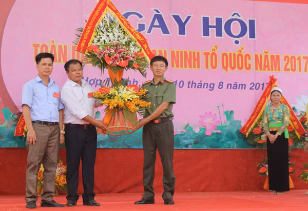 Đại tá Hoàng Văn Toàn, Phó Cục trưởng Cục Xây dựng phong trào toàn dân bảo vệ ANTQ - Bộ Công an tặng hoa chúc mừng cho đại diện lãnh đạo Đảng bộ, chính quyền xã Hợp Thành.