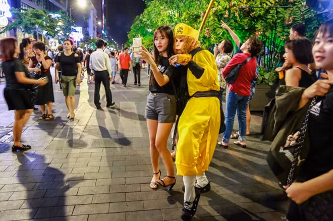Bạn trẻ chụp hình lưu niệm cùng nhân vật Tôn Ngộ Không. "Kỳ nghỉ lễ kéo dài 4 ngày nên tụi mình tha hồ có thời gian đi chơi trên phố về đêm", Diễm My, sinh viên Đại học Tự nhiên, nói.