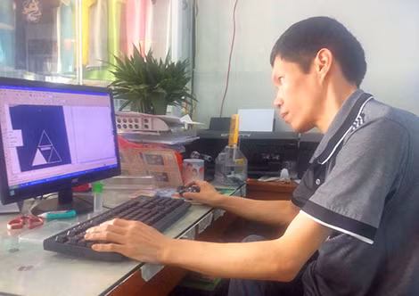 Hiền thiết kế, chỉnh sửa mẫu hình ảnh in lên áo trên máy tính.