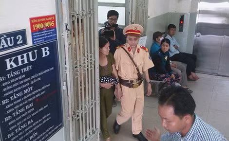 Khang nắm tay mẹ trên suốt đoạn đường từ bệnh viện ra xe mô tô.