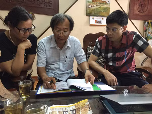 Ông Phạm Khắc Miễn và người dân ở Tổ dân phố số 18E cho phóng viên Báo CAND xem văn bản thông báo thu hồi đất bất hợp lý của UBND quận Hai Bà Trưng.