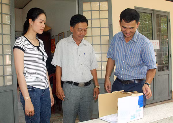 Thầy Cường hướng dẫn các giáo viên trong trường cách chấm thi trắc nghiệm bằng điện thoại.