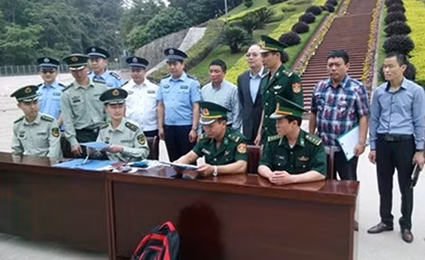 Thượng tá Tuấn (áo kẻ) cùng tổ công tác Việt Nam ký các biên bản bàn giao đối tượng truy nã cho nước bạn.