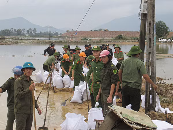 Công an tỉnh Bình Định giúp dân khắc phục hậu quả mưa lũ. (Ảnh: Hữ Toàn)