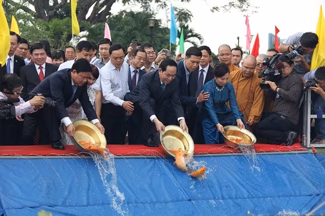 Chủ tịch nước Trần Đại Quang, lãnh đạo TPHCM cùng các kiều bào tham gia nghi thức thả cá chép trên sông Sài Gòn.
