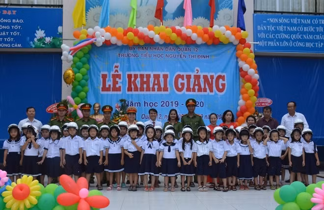 Đại diện Công an quận 12 - Đội CSGT-TT cùng Ban giám hiệu Trường Tiểu học Nguyễn Thị Định và các em học sinh được nhận mũ bảo hiểm.