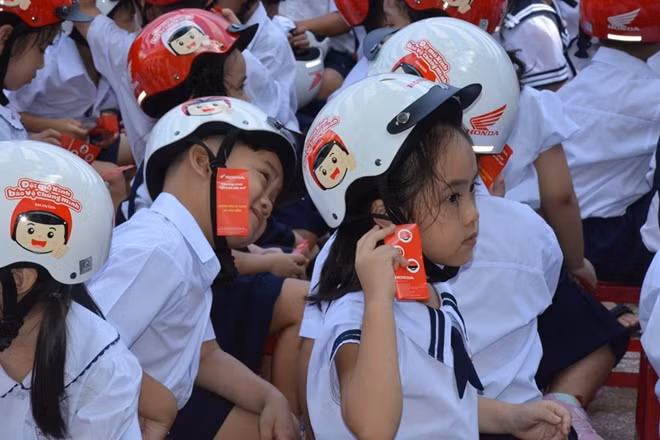 Niềm vui của các em học sinh được nhận nón.