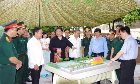 Phó Chủ tịch Thường trực Quốc hội Tòng Thị Phóng nghe lãnh đạo tỉnh Hòa Bình giới thiệu mô hình tôn tạo, phục dựng khu di tích. Ảnh: TTXVN