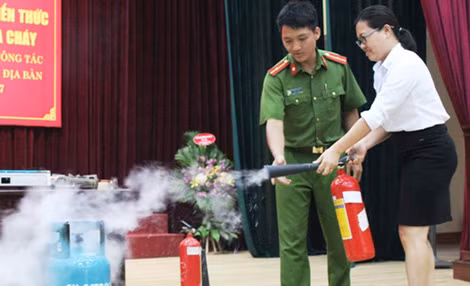 Cán bộ Cảnh sát PC&CC hướng dẫn chủ cơ sở kinh doanh sử dụng bình gas dập lửa.