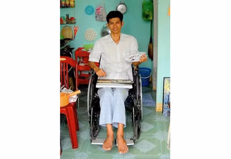 Họa sĩ Nguyễn Tấn Hiền ngồi trên xe lăn.